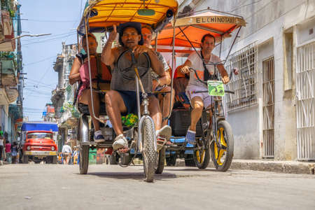 Havana, Cuba - May 16, 2019: Bicycle Taxi Driver in the street of Old Havana City during a vibrant...