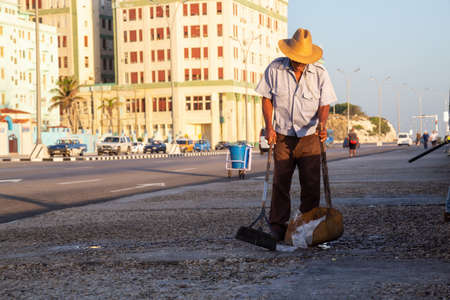 Havana, Cuba - May 14, 2019: Man doing labour work, cleaning, in the streets of Old Havana City...