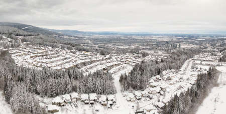 Aerial Panoramic View of a Residential Neighborhood with homes and trees covered in white after a big snow storm in the Lower Mainland. Taken in Coquitlam, Vancouver, BC, Canada.の写真素材