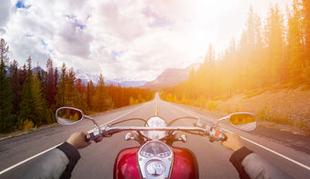 Biker Riding on a Motorcycle on a scenic Road in the Canadian Rockies. Image Composite. Background from Banff, Alberta, Canada.の写真素材
