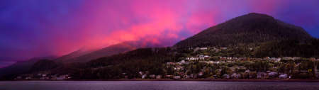 Beautiful Panoramic view of a small town, Juneau, during a cloudy morning with mountains in the background. Taken in Alaska, United States. Colorful Artistic Sky Compositeの写真素材