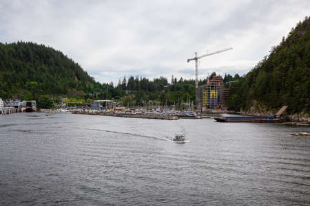 Small Boat leaving the Horseshoe Bay Terminal during a cloudy and sunny day. Taken in West...