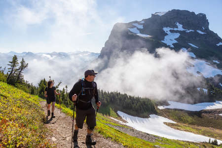 Adventurous Girl and Man Hiking in the Canadian Mountains during a sunny summer morning. Taken on...