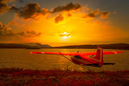Seaplane by a Scenic Lake on a Fall Day in Canadian Nature. Sunset or Sunrise Sky Overlay. Taken...