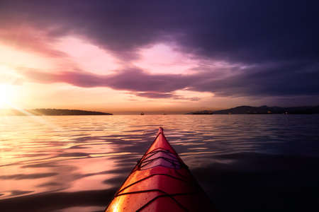 Sea Kayaking in calm waters during a colorful and vibrant sunset. Artistic Render. Location: Vancouver, British Columbia, Canada. Concept: Adventure, Explore, Recreation, Sport, Relaxingの写真素材