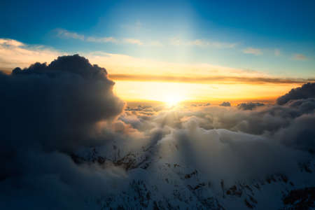 Beautiful and striking aerial view of the puffy clouds over the mountains during a colorful sunset. Taken near Vancouver, British Columbia, Canada. Magical Nature Backgroundの写真素材