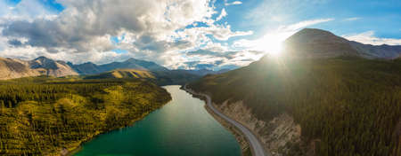 Gorgeous Panoramic View of Glacial Lake surrounded by Scenic Road at Sunset. Aerial Drone Shot. Northern Rocky Mountains, British Columbia, Canada.の写真素材