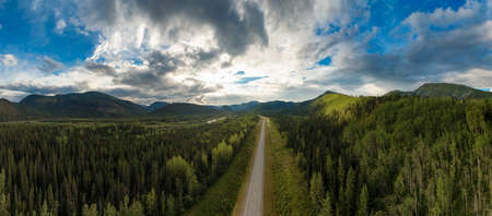 Beautiful Panoramic View of Scenic Road from Above surrounded by Lush Forest and Mountains. Aerial...