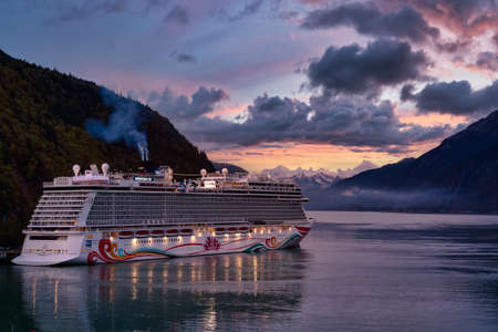 Juneau, Alaska, United States of America - September, 2019: Beautiful view of a Cruise Ship parked at a small touristic town during a cloudy summer sunset.のeditorial素材