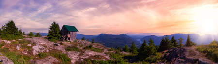 View of Tin Hat Cabin on top of a mountain. Dramatic Colorful Sunset Art Render. Located near Powell River, Sunshine Coast, British Columbia, Canada.の写真素材
