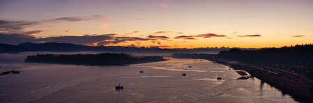 Aerial Panoramic View of Fraser River. Dramatic Colorful Sunrise Sky. Taken over Port Mann Bridge in Surrey, Vancouver, British Columbia, Canada.の写真素材