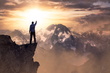 Fantasy Adventure Composite with a Man on top of a Mountain Cliff with Dramatic Landscape in...