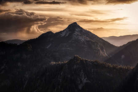 Beautiful aerial landscape view of Mountain Peaks near Vancouver, British Columbia, Canada. Dramatic Stormy Cloudy Sunset Sky Art Render.の写真素材