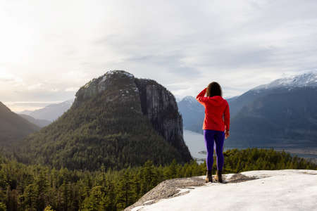 Adventurous Girl Hiking in the mountains during a sunny Autumn Sunset. Taken in Squamish, North of Vancouver, British Columbia, Canada. Concept: Adventure, freedom, lifestyle, health, sportの写真素材
