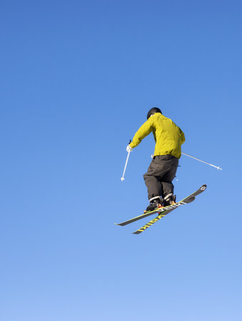 whistler, British Columbia, Canada - Jan 18, 2021: Extreme Skier jumps up high with blue sunny sky...