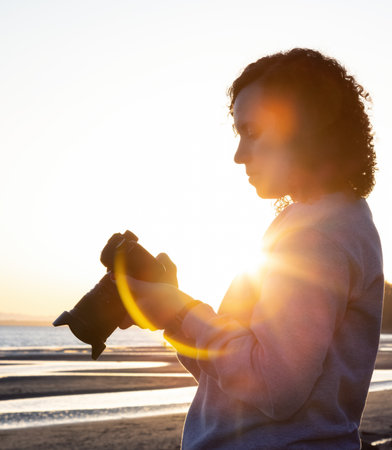 Adventure Travel Photographer at West Pacific Ocean Coast. Colorful Sunny Sunset. Adult White Caucasian Woman. Location: White Rock, Greater Vancouver, BC, Canada.の写真素材