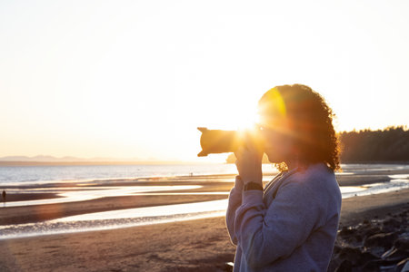 Adventure Travel Photographer at West Pacific Ocean Coast. Colorful Sunny Sunset. Adult White...
