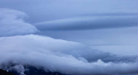 Panoramic View of Puffy Clouds over the Canadian Mountain Landscape. Colorful Winter Sunset Cloudscape Background. Taken between Squamish and Whistler, British Columbia, Canada.の写真素材