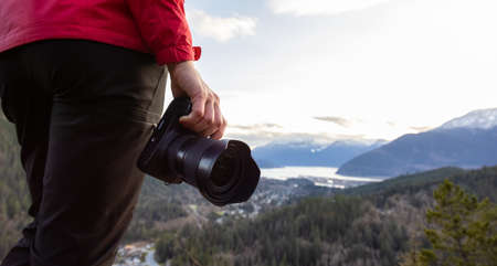 Adventure Travel Photographer Hiking in the mountains and taking pictures during a Spring Sunset....