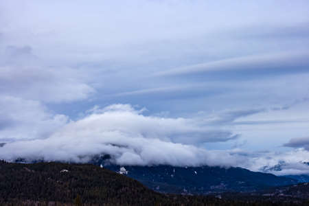 View of Puffy Clouds over the Canadian Mountain Landscape. Colorful Winter Sunset Cloudscape...