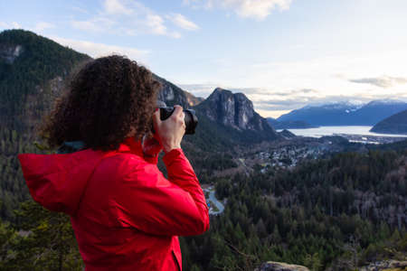 Adventure Travel Photographer Hiking in the mountains and taking pictures during a Spring Sunset. Squamish, North of Vancouver, British Columbia, Canada.の写真素材