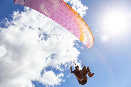 Savona, British Columbia, Canada - May 11, 2021: Adventurous Man Flying on a Paraglider around the mountains.のeditorial素材