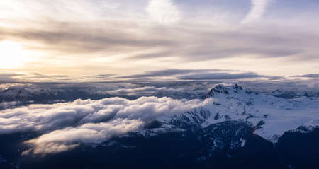 Aerial View from Airplane of Canadian Mountain Landscape in Spring time. Colorful Sunset Sky. Garibaldi Peak near Squamish and Vancouver, British Columbia, Canada. Authentic Imageの写真素材