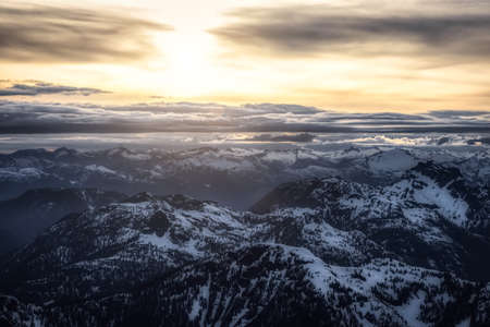 Aerial View from Airplane of Canadian Mountain Landscape in Spring time. Colorful Sunset Sky. North of Vancouver, British Columbia, Canada. Dark Moody Art Renderの写真素材