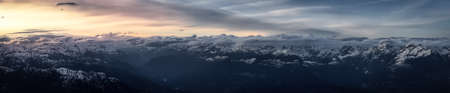 Aerial Panoramic View from Airplane of Canadian Mountain Landscape in Spring time. Colorful Sunset. North of Vancouver, British Columbia, Canada. Nature Panorama, Dark Moody Art Renderの写真素材