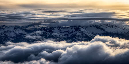 Aerial View from Airplane of Canadian Mountain Landscape in Spring time. Colorful Sunset Sky. North of Vancouver, British Columbia, Canada. Dark Moody Art Renderの写真素材