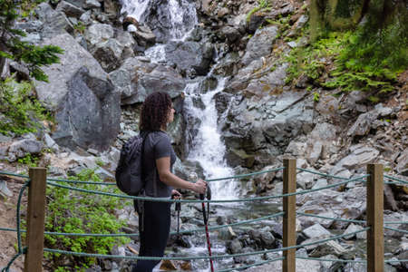 Adventurous White Caucasin Adult Woman Hiking on a trail in Canadian Nature. Garibaldi Lake Hike near Whistler and Squamish, British Columbia, Canada.の写真素材