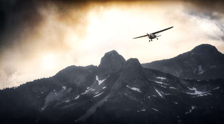 Airplane flying near the Beautiful Canadian Mountain Nature Landscape. Adventure Composite. Cloudy...