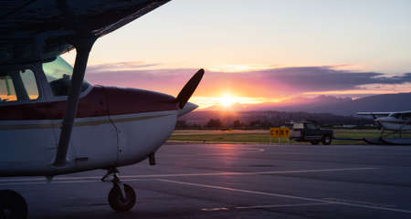 Airplanes parked at an Airport during a colorful summer sunset. Pitt Meadows, Vancouver, British Columbia, Canadaの写真素材