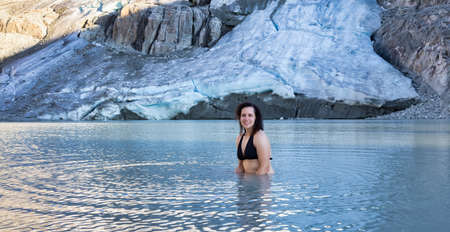 Adventurous White Caucasian Adult Woman Swimming in Ice Cold Glacier Lake on top of a Mountain. Wedgemount, Whistler, BC, Canada.の写真素材