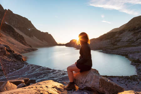 Adventurous Caucasian Adult Woman Hiking on top of a Canadian Rocky Mountain. Sunny Summer Sunset. Wedgemount, Whistler, British Columbia, Canada.の素材 [FY310173788289]