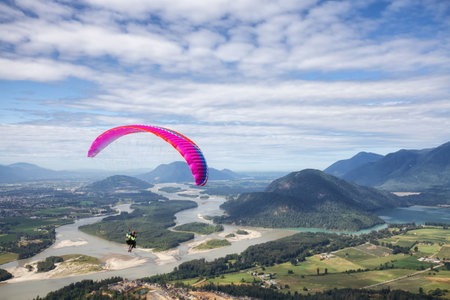 Harrison Mills, British Columbia, Canada - July 24, 2021: Adventurous people Paragliding around the Canadian mountains during summer evening.のeditorial素材