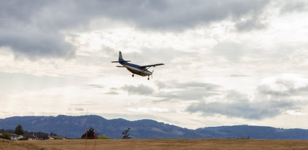 Sidney, Victoria, Vancouver Island, British Columbia, Canada - August 16, 2021: Small Airplane Landing at the Airport during a cloudy summer day.のeditorial素材