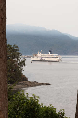 Victoria, Vancouver Island, British Columbia, Canada - August 13, 2021: BC Ferries Boat Leaving the Terminal in Swartz Bay during smoke covered sky from BC forest fires.のeditorial素材