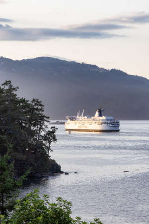 Victoria, Vancouver Island, British Columbia, Canada - August 21, 2021: BC Ferries Boat Leaving the Terminal in Swartz Bay during a cloudy summer sunset.のeditorial素材