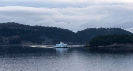 Mayne Island, British Columbia, Canada - August 27, 2021: BC Ferries Boat in Pacific Ocean during cloudy summer morning sunrise.のeditorial素材