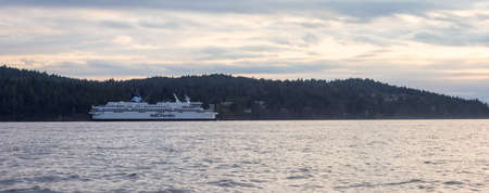 Victoria, Vancouver Island, British Columbia, Canada - August 20, 2021: BC Ferries Boat leaving the Terminal in Swartz Bay during cloudy summer sunset.のeditorial素材