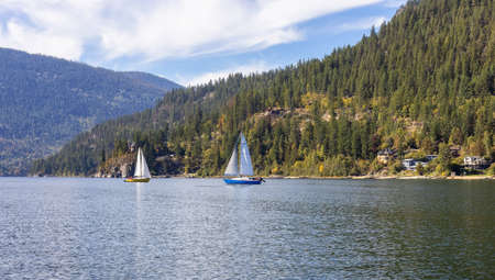 Scenic View of Kootenay River with Sailboat. Sunny Fall Season Morning. Located in Nelson, British Columbia, Canada.の写真素材