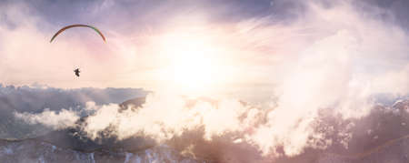 Aerial View of Canadian Rocky Mountains with snow on top. Paraglider flying Adventure Composition. Colorful Sunset Sky Art Render. Nature Landscape near Chilliwack, East of Vancouver, BC, Canada.の写真素材