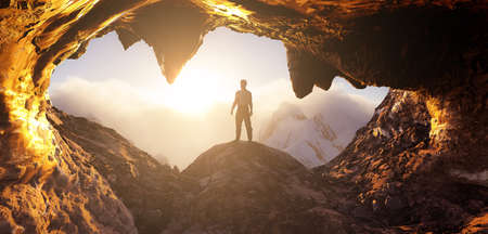 Dramatic Adventurous Scene with Man standing inside an Alien like Rocky Cave Landcspae. 3d Rendering. Sunset Sky. Aerial Mountain Image from British Columbia, Canada. Adventure Conceptの写真素材