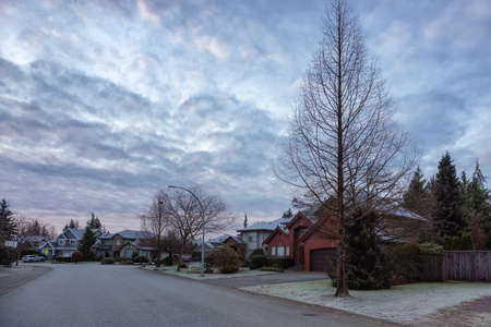 Residential Suburban Neighborhood Street in a modern city. Frosty Cloudy Winter Morning Sunrise Sky. Fraser Heights, Surrey, Vancouver, British Columbia, Canada.の写真素材