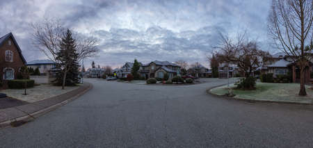 Panoramic View of Residential Suburban Neighborhood Street in a modern city. Frosty Cloudy Winter Morning Sunrise Sky. Fraser Heights, Surrey, Vancouver, British Columbia, Canada.の写真素材