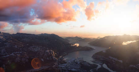 Aerial View of a small city, Squamish, in Howe Sound during winter season. Located north of Vancouver, British Columbia, Canada. Dramatic Sunset Sky Art Renderの写真素材