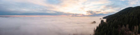 Panoramic View of Canadian Nature Mountain Landscape covered in cloud and fog. West Vancouver, British Columbia, Canada. Aerial background panoramaの写真素材