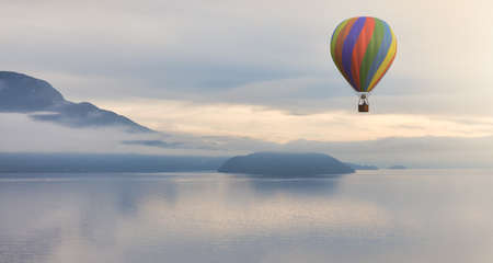 Hot Air Balloon flying over Canadian Mountain Nature Landscape on the Pacific West Coast. Cloudy and fog Winter Day. 3d Rendering aircraft Adventure Concept. Howe Sound, British Columbia, Canada.の写真素材