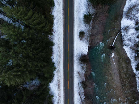 Aerial View from above of Road by Fresh Water flowing down a river creek during winter. Canadian Nature Background. Taken near Chilliwack, British Columbia, Canada.の写真素材